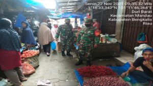 Ket : Sertu Ali Naspi bersama Tim lakukan kegiatan penerapan 3 M bagi masyarakat yang ketahuan tidak menggunakan masker akan di berikan sanksi tegas (foto/Istimewa).