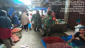Ket : Sertu Ali Naspi bersama Tim lakukan kegiatan penerapan 3 M bagi masyarakat yang ketahuan tidak menggunakan masker akan di berikan sanksi tegas (foto/Istimewa).
