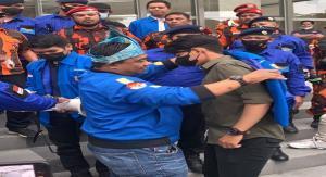 Teks foto : Haris Pertama memberikan baju KNPI sekaligus memasangkannya kepada dua orang koordinator lapangan massa aksi (Istimewa).
