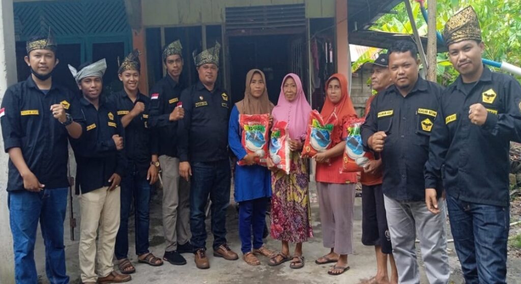 Iskandar Izhar bersama Pasukan Adat dan Marwah Gagak Hitam Berbagi Sembako Kepada Warga di Desa Senggoro