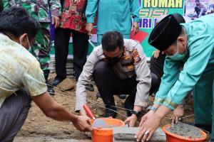 Teks foto : AKBP Bachtiar Alponso S.I.K, M.Si, disaksikan langsung oleh Plt Camat Lirik Drs Sugeng Misman letakan batu pertama pembangunan bedah Rumah Presisi